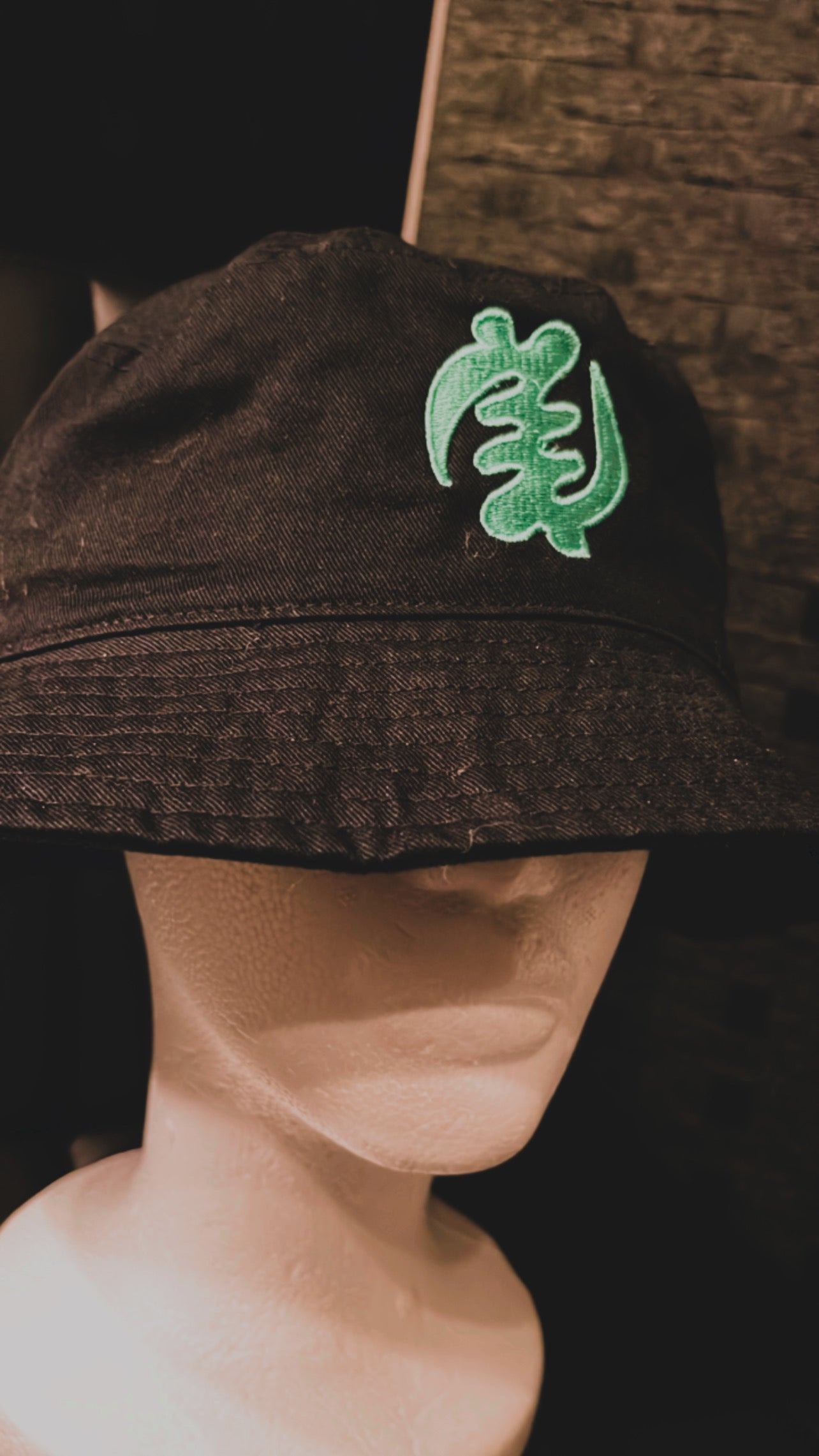 Get a stylish and unique look with our black bucket hat featuring the iconic Gye Nyame symbol in mint blue. Handmade in Ghana, this hat is perfect for any occasion. Shop now and add a touch of African culture to your wardrobe!